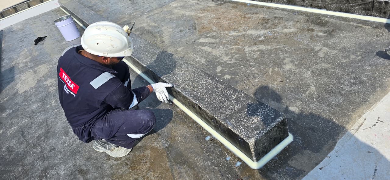 TEXSA technician detailing the edge bead between a polyurea-coated upstand and slab