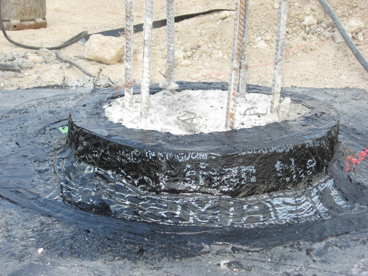 Close-up of bitumen-wrapped pile head collar