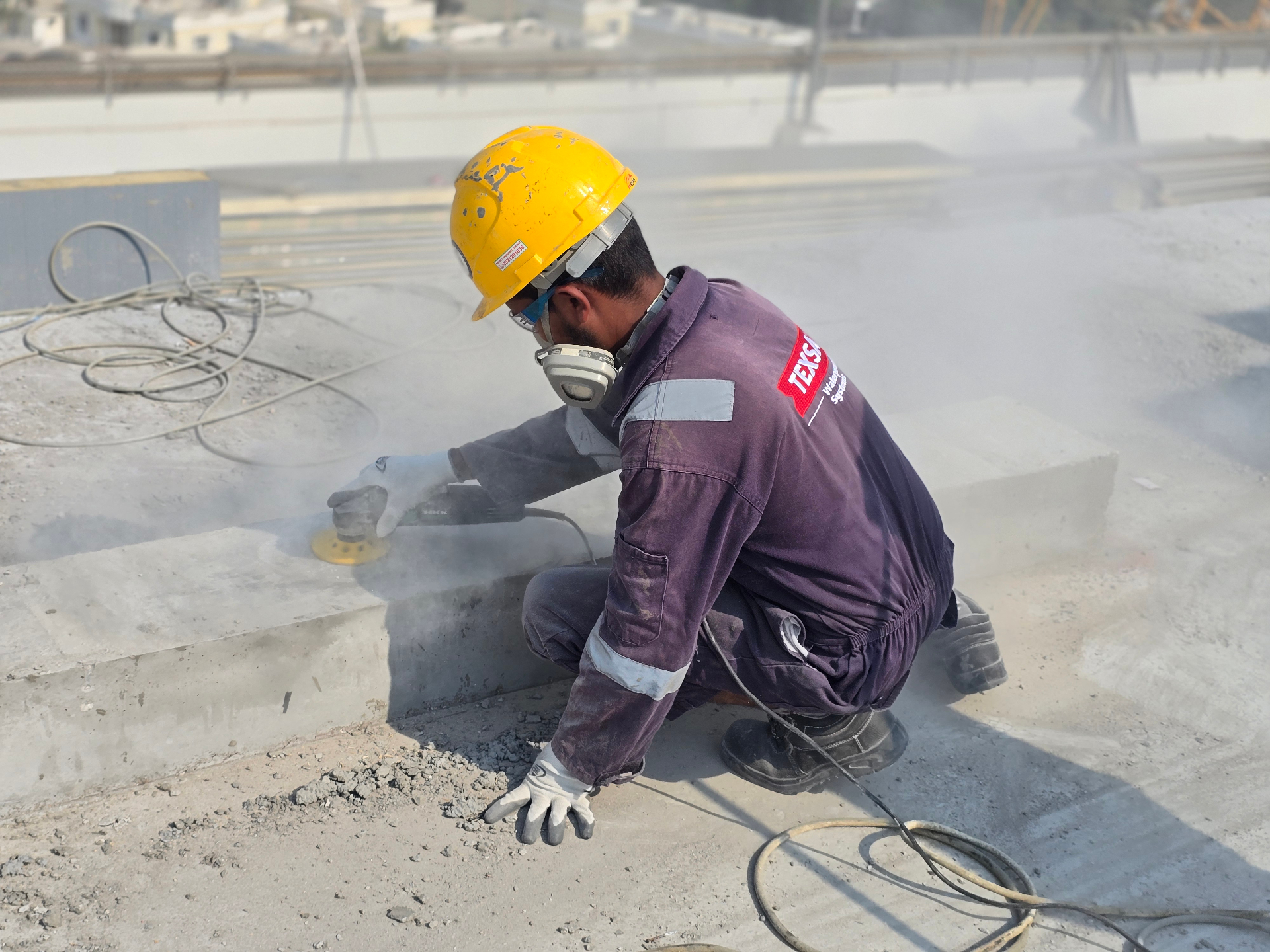 TEXSA technician grinding an upstand to expose a sound concrete substrate