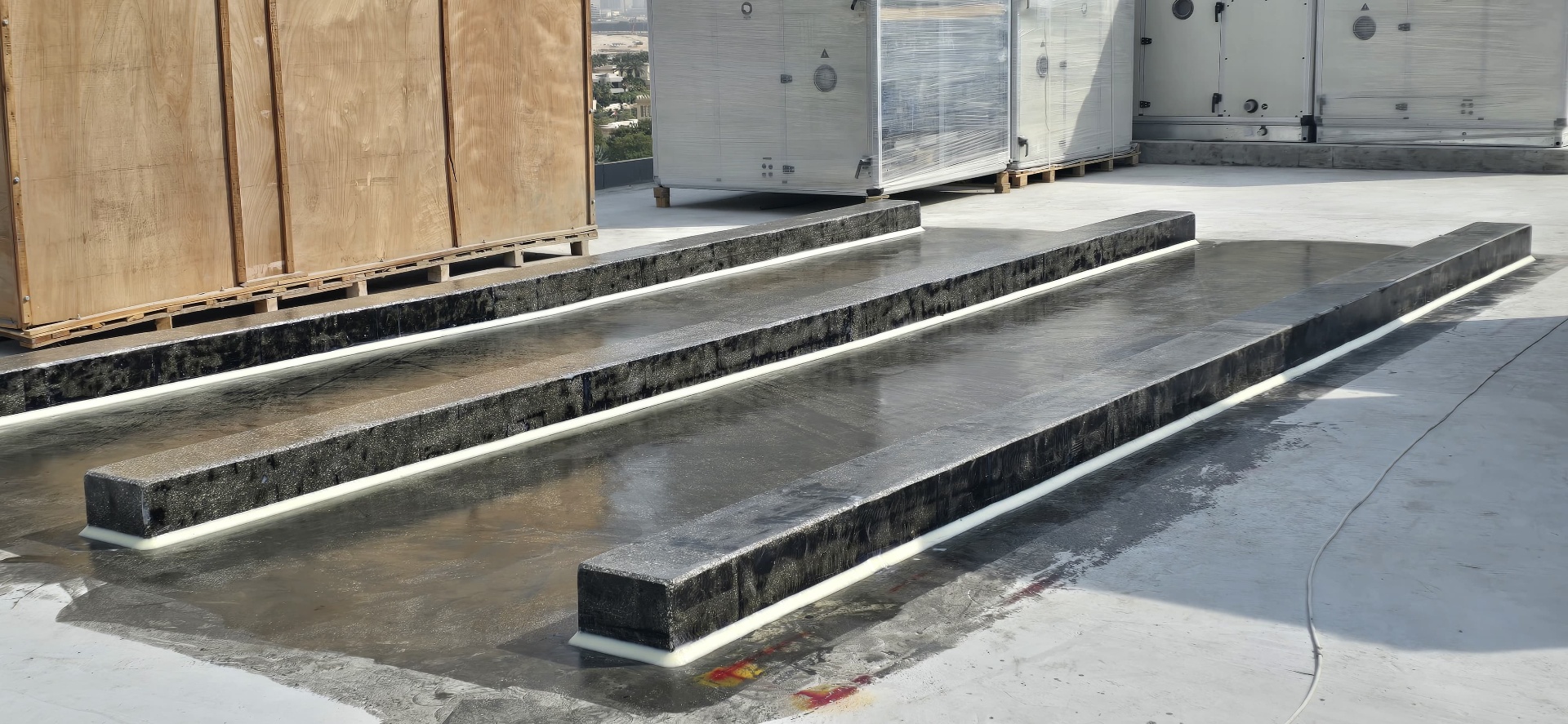 Three parallel polyurea-coated upstands on a high-rise rooftop